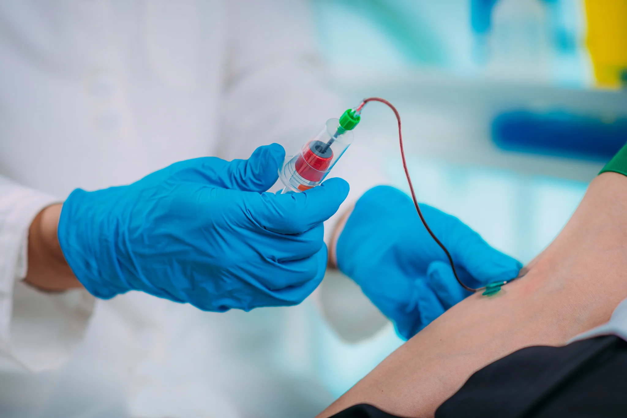 Medical,Worker,With,Ppe,Taking,Blood,Sample,From,Patient,In Medical worker with PPE taking blood sample from patient in a hospital